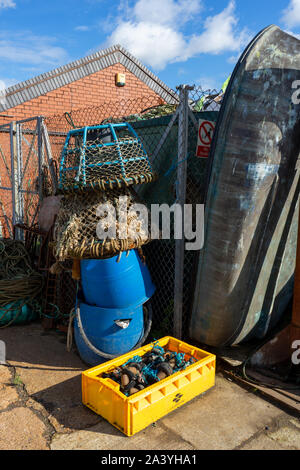 fishing pots and an old boat stood up next to them Stock Photo