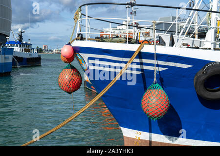 The bow of a fishing trawler tied up on the dockside or quay Stock Photo