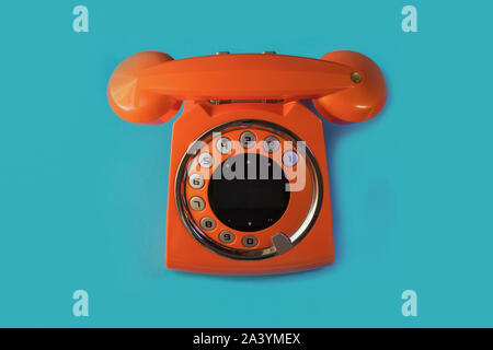 Orange vintage telephone retro style isolated on a blue background Stock Photo