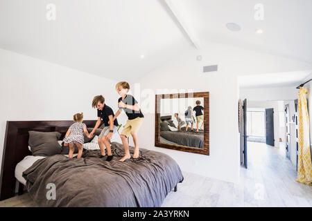 Children jumping on bed Stock Photo