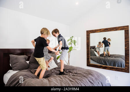Children jumping on bed Stock Photo