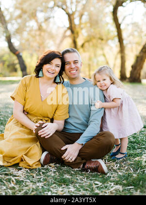 Mid adult couple sitting with their daughter in park Stock Photo