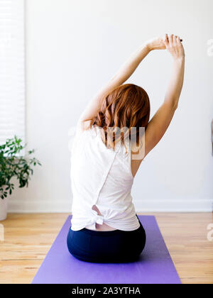 Rear view of woman practicing yoga Stock Photo