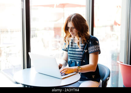 Woman using laptop in cafe Stock Photo
