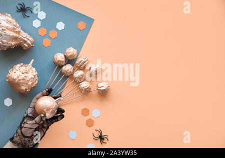 Creative paper craft Halloween background. Flat lay with spiders, pumpkins and hexagons on split paper background in lorange and greywith copy-space. Stock Photo