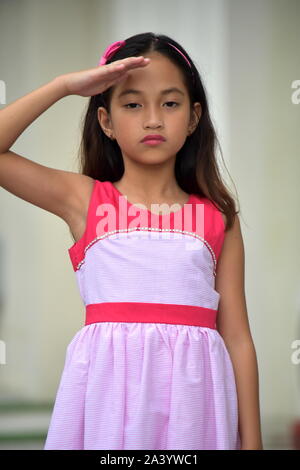 Saluting Youthful Asian Girl Child Stock Photo