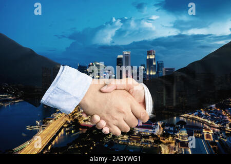 double exposure, cooperation or partnership business shaking hand with partnership after making profitable agreement with singapore city in background Stock Photo