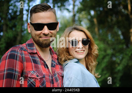 Portrait of happy smiling hipsters couple in sunglasses spending time together outdoors in the park Stock Photo