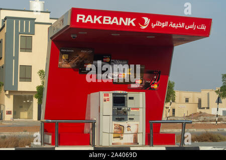 'Ras al Khaimah, RAK/ United Arab Emirates - 10/10/2019: RAK Bank red logo atm sign in evening on a main road in the northern Emriates' Stock Photo