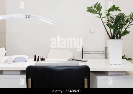 Interior of empty modern nail and beauty salon. Long table with lamp, manicure interior business Stock Photo