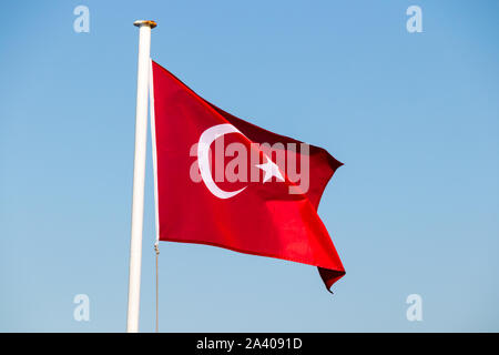 Turkish flag fluttering in the breeze against a bright blue sky, Bodrum, Turkey Stock Photo