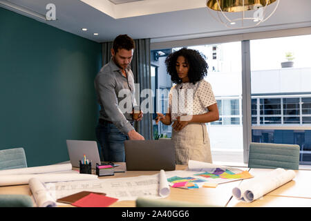 Two young creative professionals working together in a modern office Stock Photo