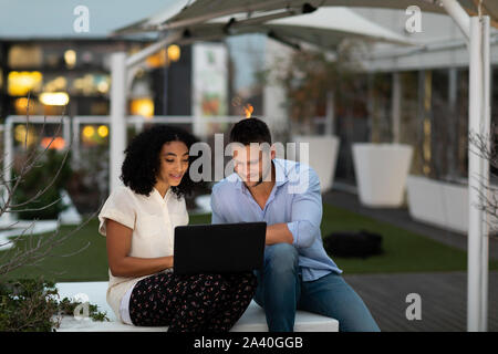 Two young creative professionals working on an office roof terrace Stock Photo