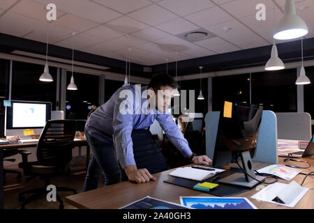 Young male professional working late in creative office Stock Photo