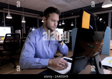 Young male professional working late in creative office Stock Photo