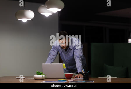 Young male professional working late in creative office Stock Photo