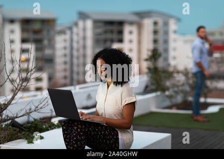 Two young creative professionals working on a office roof terrace Stock Photo