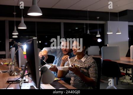 Two young creative professionals working late in a modern office Stock Photo