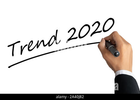 business man hand writing word trend 2020 with black color marker pen isolated on white background.TRENDS 2020 Business Concept Stock Photo