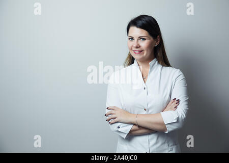 Portrait of female dentist .She standing in her dentist office. Female dentist wearing a white robe Stock Photo