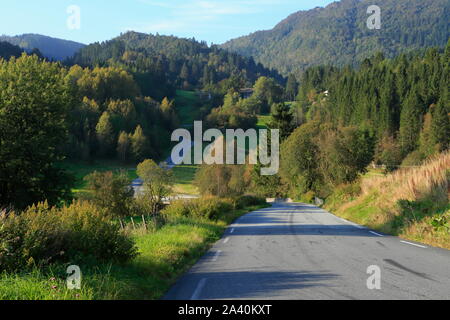 A tarred country road runs through the rural landscape on the island of Osterøy in Vestland county, Norway. Stock Photo