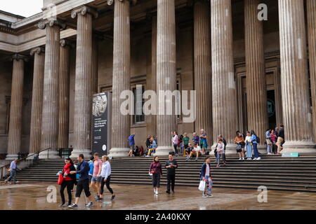 People outside South entrance of the British Museum in London, United Kingdom, on a rainy afternoon during the summer. Stock Photo