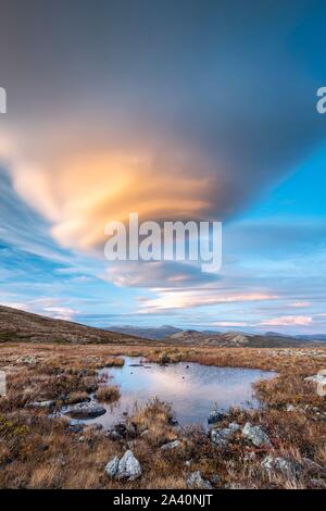 Autumnal Tundral landscape in Dovrefjell at evening mood, Lenticularis cloud, Dovrefjell-Sunndalsfjella National Park, Hjerkinn, Norway Stock Photo