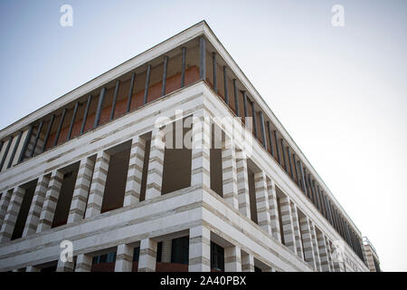 Corner building that presents absence of windows but complements such lack with many columns Stock Photo