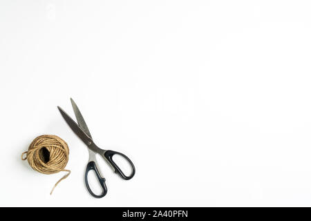 Ball of Brown String and Scissors on White Background Stock Photo