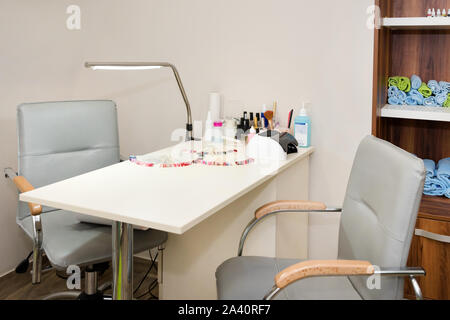 Interior of empty modern nail and beauty salon. Table with lamp, manicure interior business Stock Photo
