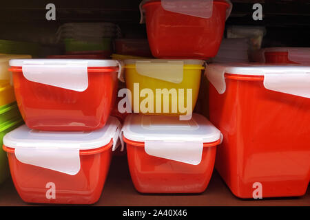 Red food containers with a tight lid. Special boxes for storing food and cooked food. Plastic containers of different sizes on the shelves of the stor Stock Photo