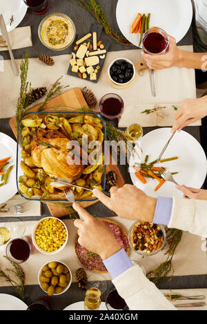 Close-up of man cutting roast turkey and is going to eat it at the table during holiday dinner Stock Photo