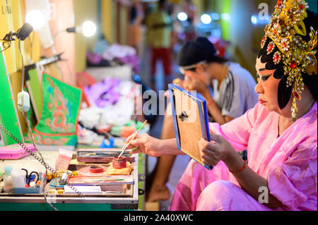 Chinese opera actor performer applies makeup backstage Stock Photo