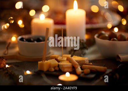 Close-up of cheese appetizer on the dining table with candles ready for dinner Stock Photo