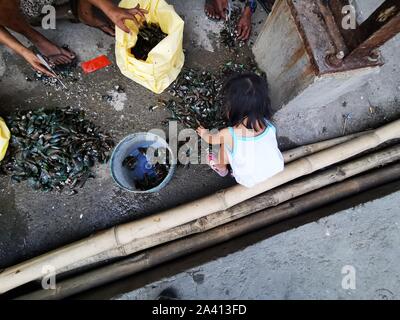 Bacoor City, Philippines. 10th Oct, 2019. Women and their kids cleaning ...