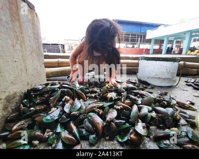 Bacoor City, Philippines. 10th Oct, 2019. Women and their kids cleaning ...