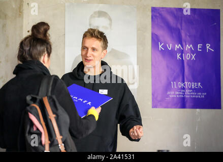 11 October 2019, Saxony, Chemnitz: Felix Kummer, frontman of the Chemnitz band Kraftklub, signs autographs in his recently opened record store. Previously hundreds of fans had been feverishly anticipating this moment, sometimes singing loudly. Kummer wants to personally sell his first solo album 'Kiox' for three days. On the new album, the 30-year-old raps in the song '9010' about his youth in Chemnitz, among other things - and the everydayness of right-wing violence long before the current events. Photo: Jan Woitas/dpa-Zentralbild/dpa Stock Photo