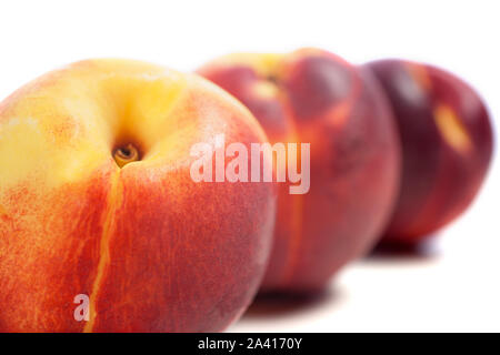 Three fresh nectarines on an isolated background Stock Photo
