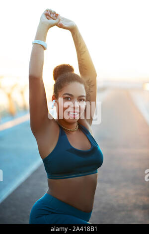 Dark-eyed woman stretching her body before starting workout Stock Photo