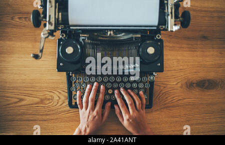 High angle view of secretary prints on retro typing machine Stock Photo