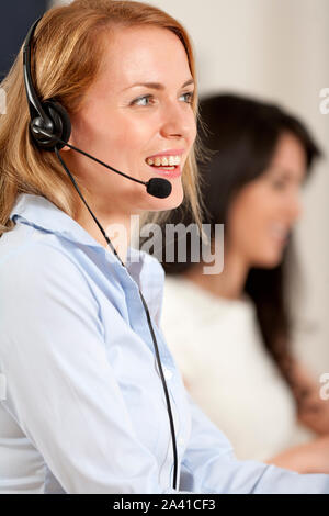Two colleagues working in a busy call centre office. Stock Photo