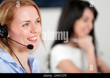 Two colleagues working in a busy call centre office. Stock Photo