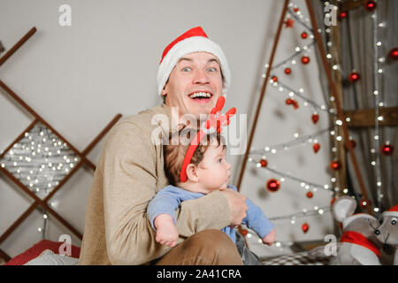 Dad with his son hugging and having fun. Love, happiness and the concept of a large family. father and son have fun in the new year. New Year decor. Stock Photo