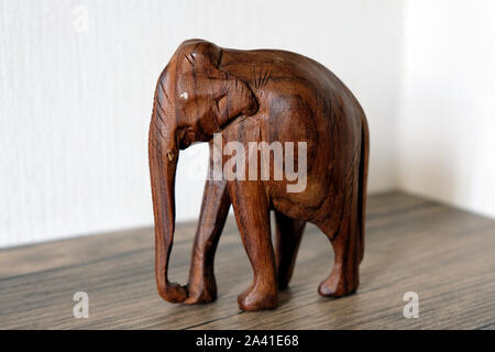 Statuette of an elephant on a shelf, wooden elephant dark brown color close-up. Stock Photo
