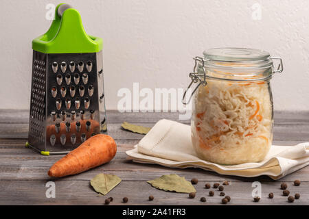 https://l450v.alamy.com/450v/2a41fr3/homemade-canned-cabbage-in-a-jar-with-bay-leaves-on-a-wooden-table-near-grater-and-carrots-rustic-style-2a41fr3.jpg