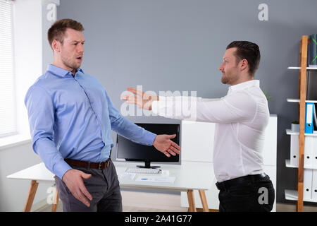Two Angry Young Businessmen Quarreling With Each Other Fighting In The Office Stock Photo