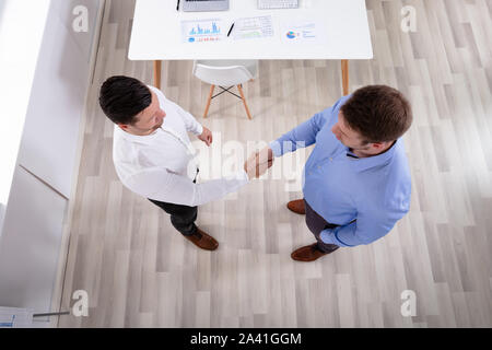 An Elevated View Of Two Businessmen Standing In The Office Shaking Hands Stock Photo