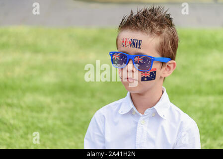 Portrait of Australian boy with flag tattoo on his chick and sunglasses on Australia Day Stock Photo
