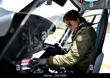 (191011) -- LHASA, Oct. 11, 2019 (Xinhua) -- Jianre Yixi prepares to fly a helicopter in southwest China's Tibet Autonomous Region, Aug. 7, 2019. The Qinghai-Tibet Plateau was once known as a 'no-fly zone' and it was extremely difficult to fly helicopters there. Now, after professional and intensive training, the first batch of young Tibetans has flown civilian helicopters to the Mt. Qomolangma base camp.     Jianre Yixi is from an impoverished herdsman family in Damxung County, Tibet. In 2016, Jianre Yixi, a student at Lhasa's No. 2 Secondary Vocational and Technical School, received a call t Stock Photo