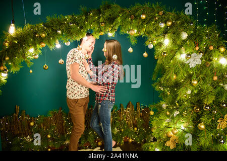 couple in love near christmas background. Young couple kissing near Christmas tree. Low key. Silhouette Stock Photo